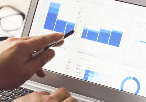 Businessman using internet analytics in the office on the touch screen of his laptop (reduced tone)